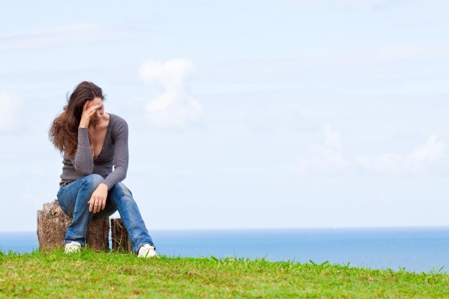 Depresívne, smutné a rozrušené mladá žena sedí vonku