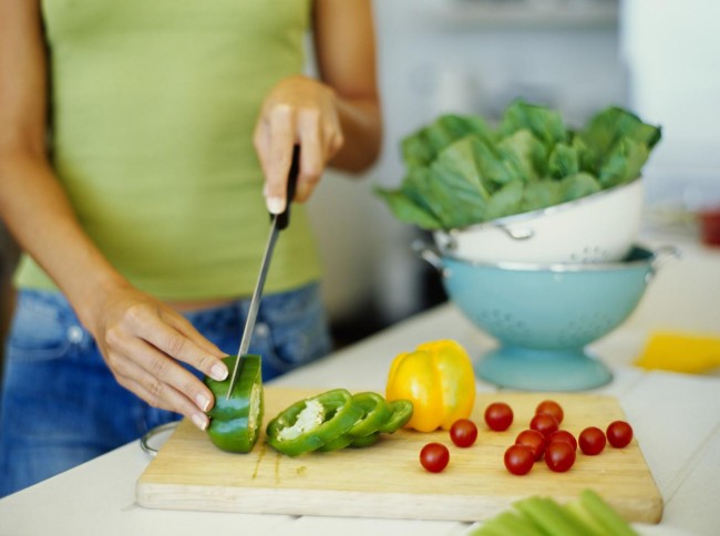 mid section view of a woman cutting vegetables