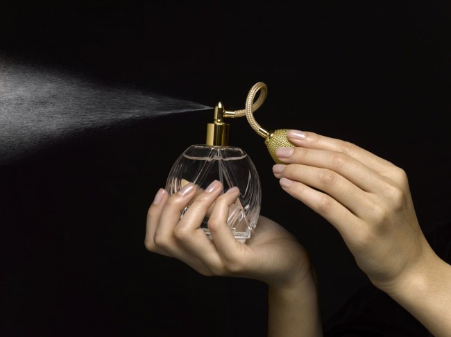 Femeie pulverizare parfum cu atomizer parfum, close-up de mâini