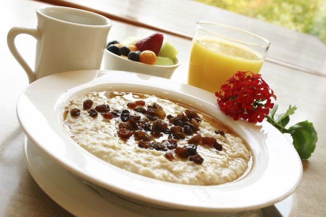 صبحانه از جو دوسر تازه آماده شده با کشمش. با انتخاب شما از قهوه یا آب پرتقال و یک فنجان میوه خدمت کرده است.