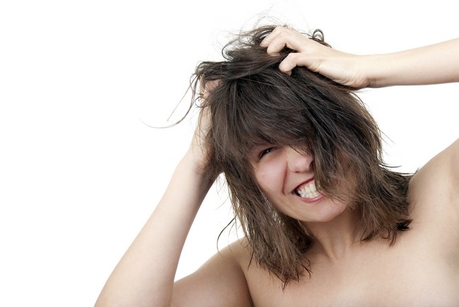 Tânăra femeie se zgârie furios părul încurcat