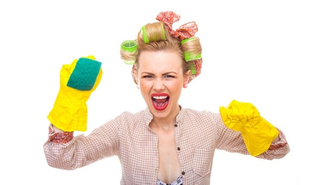 Funny young housewife with gloves holding scrubberr, isolated on white. Pin-up girl