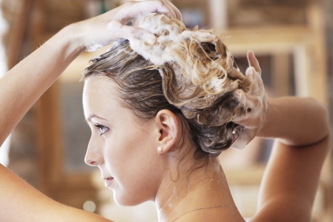Mladá žena umývanie vlasov, close-up