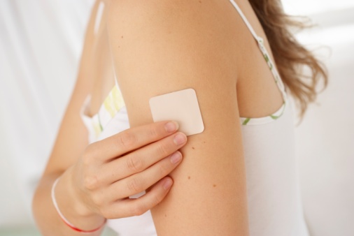 Woman Placing Nicotine Patch On Her Arm, Close-Up