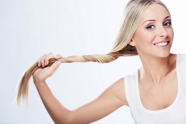 Linda garota segurando o cabelo em um fundo branco