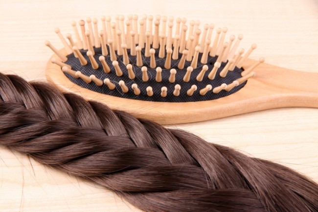 Long Brown Hair With Hairbrush on Wooden Background