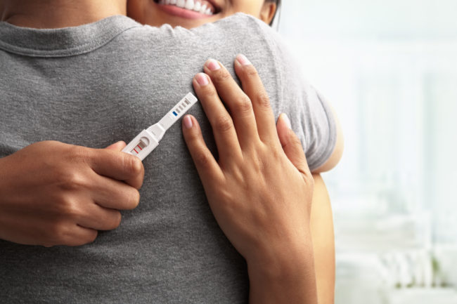 Joyful couple avec grossesse positif montré dans le dispositif de test