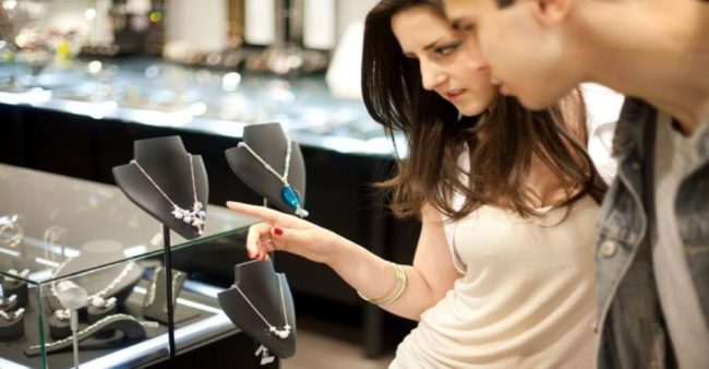 Attractive young couple looking at an expensive necklace in a jewelry store