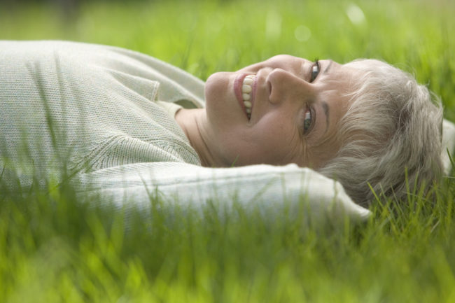 Bezstarostná žena leží v tráve