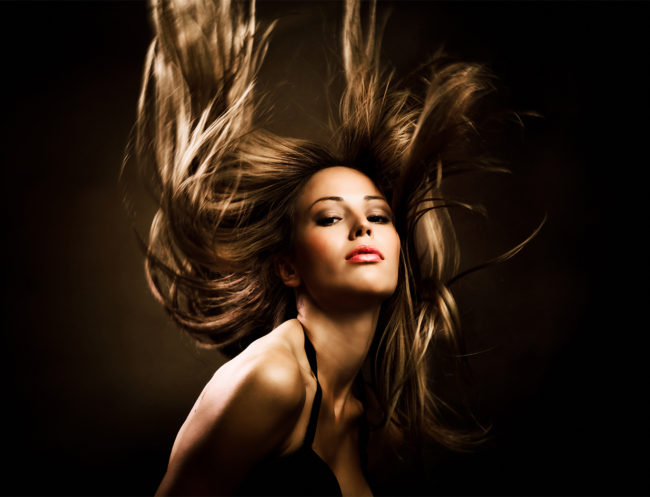 زن زیبا با موهای بلند طلایی در حرکت، استودیو شات