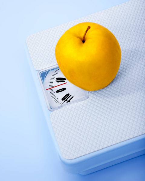 Apple в мащаба, телесното наблюдение, концептуален образ на диетата, броя на калориите, здравословния начин на живот и контрол на формата